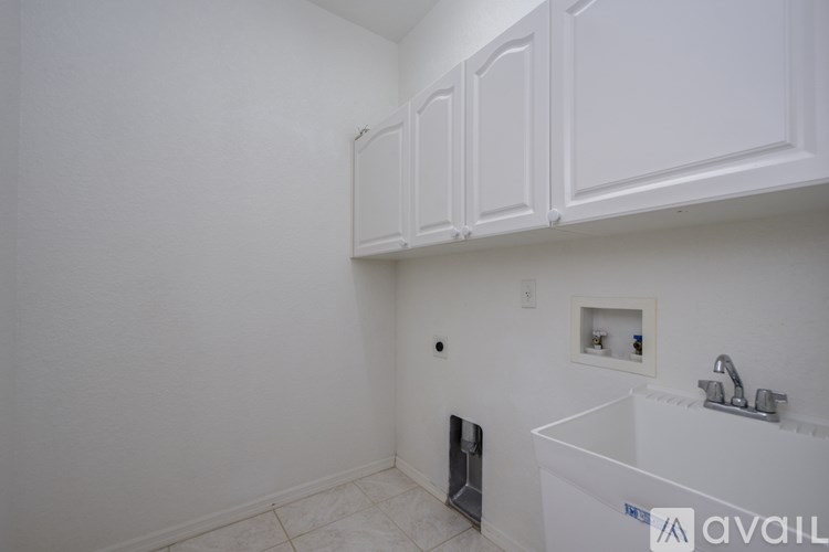 A white bathroom with a sink and a cabinet.