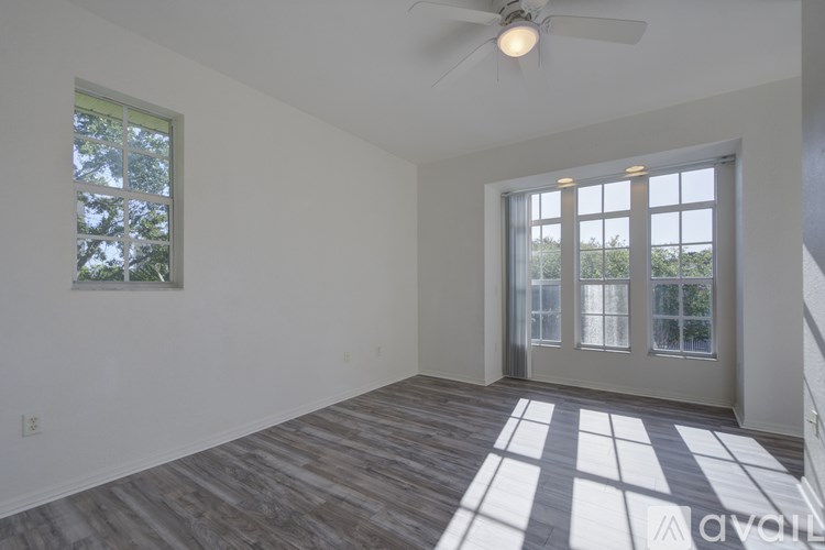 A room with a ceiling fan and a checkered floor leading to a glass door.