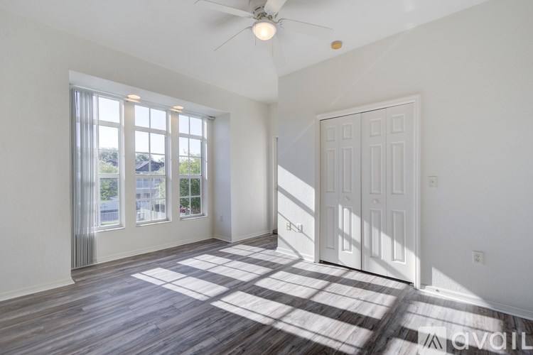 A room with a ceiling fan and a checkerboard floor.