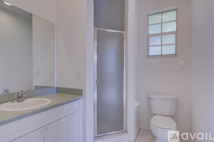 A bathroom with a toilet, sink, and shower.