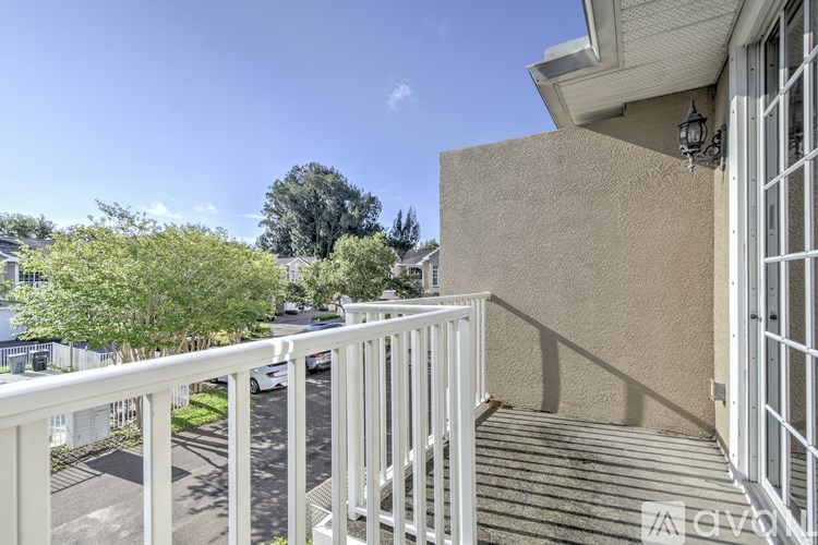 A balcony with white railings and a beige wall.