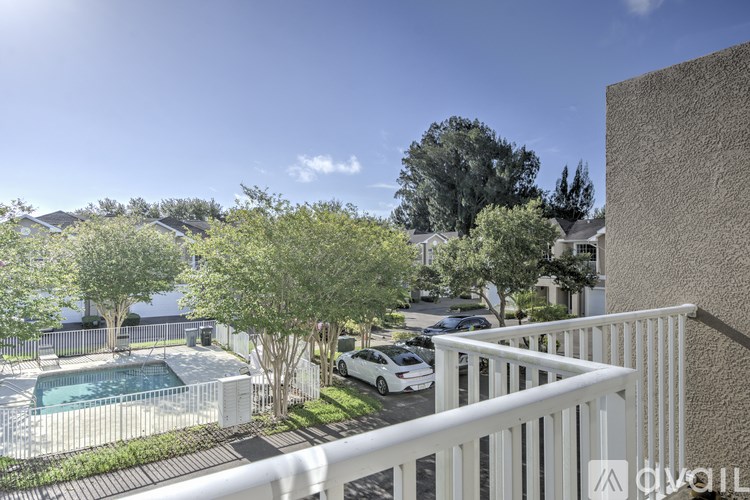 A balcony overlooks a pool and a residential area.
