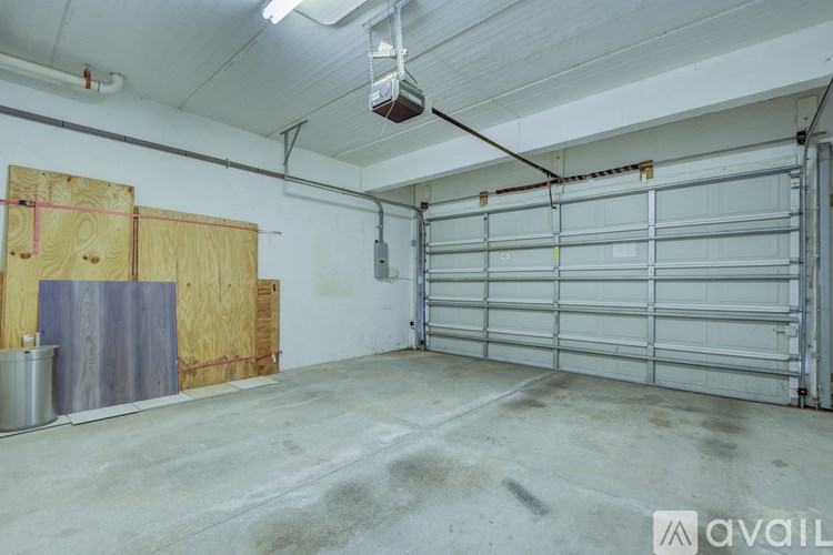A large garage with a white ceiling and a closed white door.