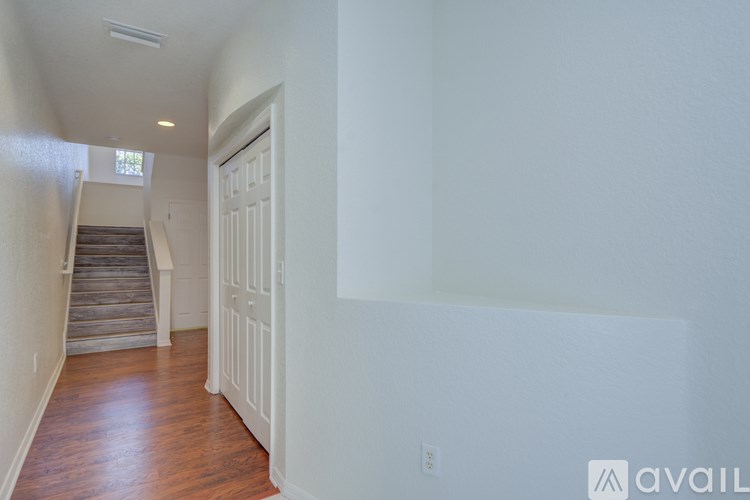 A hallway with a staircase and a white door.
