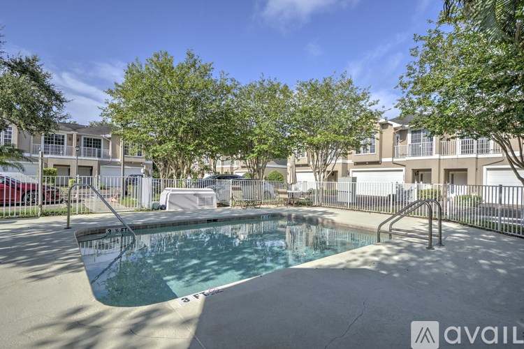 A swimming pool surrounded by trees and apartment buildings.