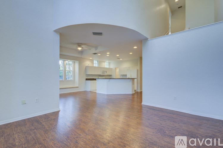 A spacious room with wooden floors and white walls.