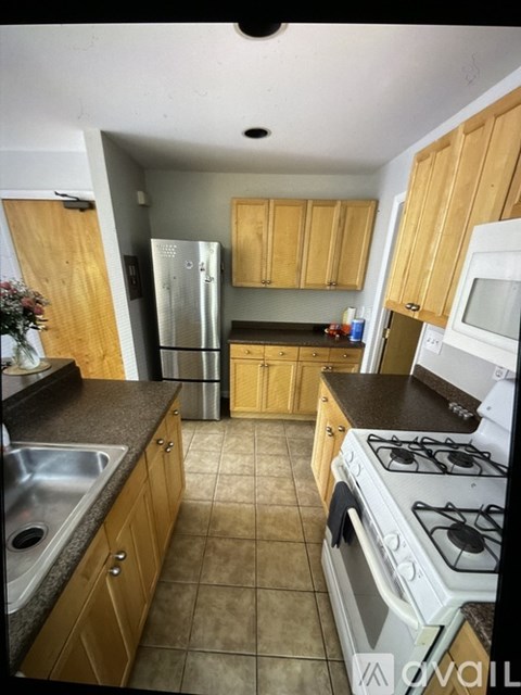 A kitchen with wooden cabinets and a white stove top oven.