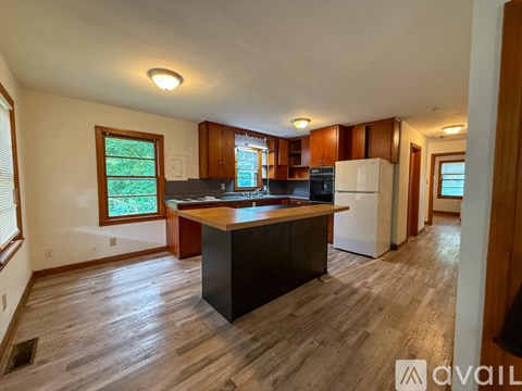 A kitchen with a black island in the middle of the room.