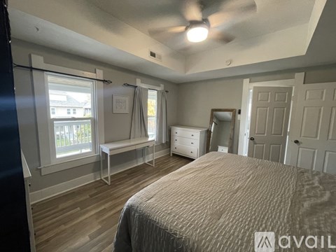 A bedroom with a bed, dresser, and window.