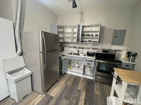 A modern kitchen with stainless steel appliances and wooden flooring.
