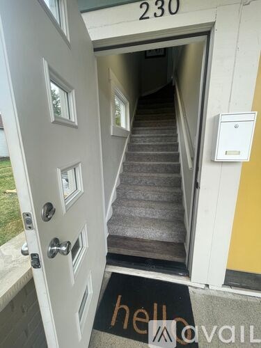 A white door with a glass window and a mailbox on the wall.