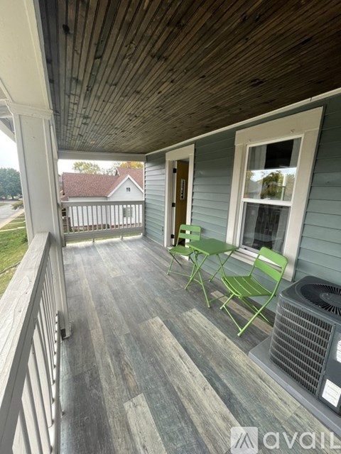 A balcony with a table and chairs and an air conditioning unit.