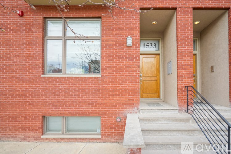 A red brick house with a wooden door and a window.
