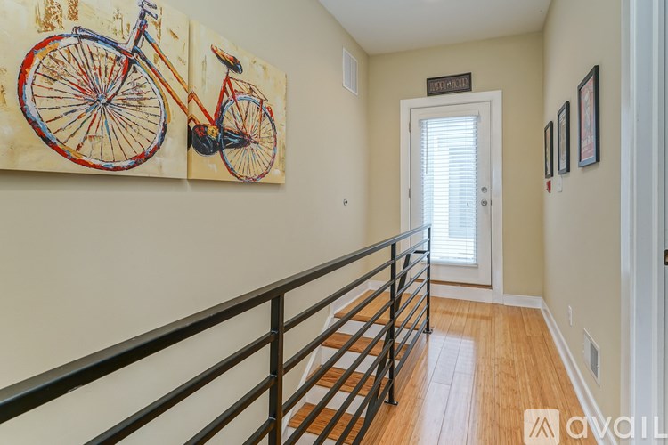 A hallway with a bicycle painting on the wall and a railing on the floor.