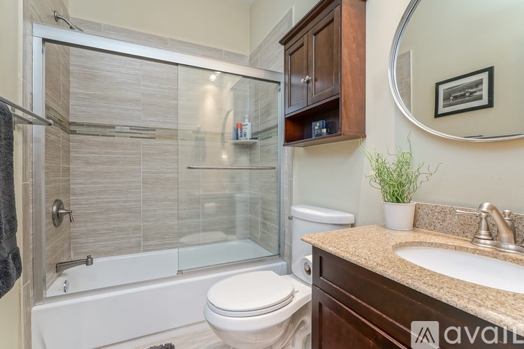 A bathroom with a toilet, sink, and shower.
