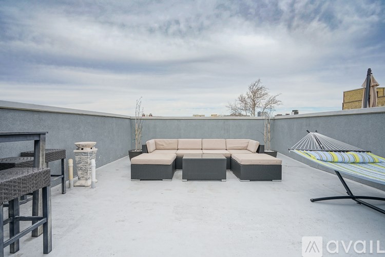 A patio with a couch, chairs, and a table.