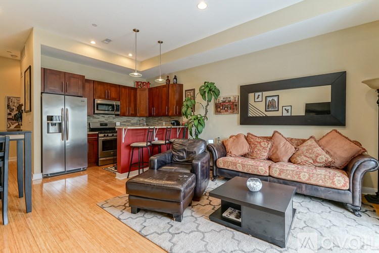 A living room with a couch, coffee table, and kitchen area.