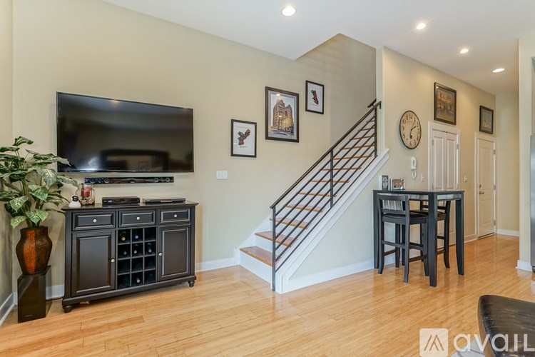 A living room with a staircase and a flat screen TV.