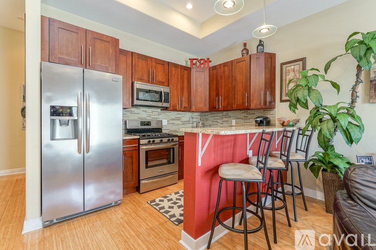 A kitchen with wooden cabinets and a stainless steel refrigerator.