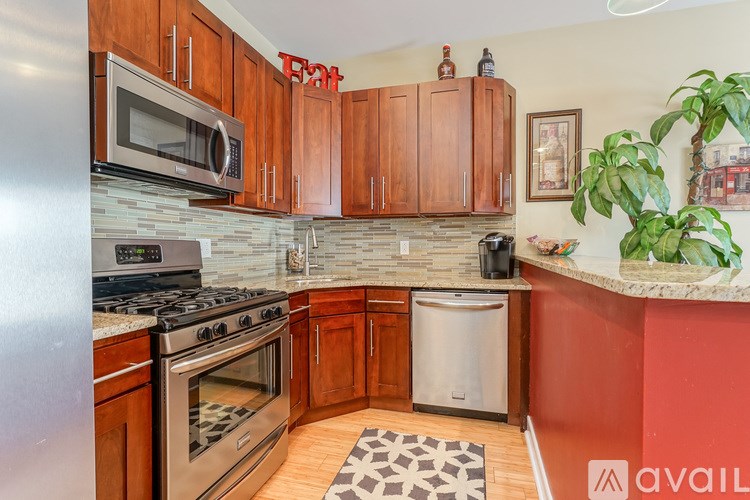 A kitchen with wooden cabinets and a stainless steel refrigerator.