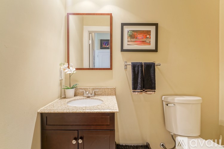 A bathroom with a sink, mirror, towel rack, and a toilet.