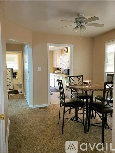 A dining room with a table and chairs.