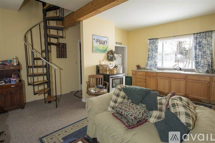 A living room with a spiral staircase and a couch.