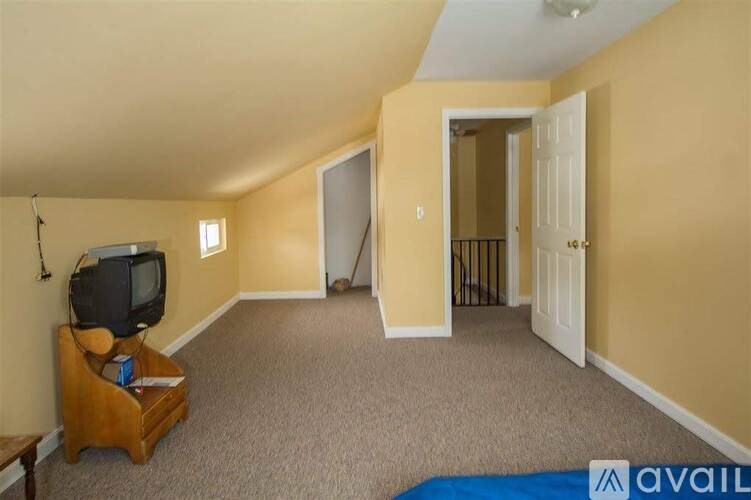 A room with a television and a carpeted floor.