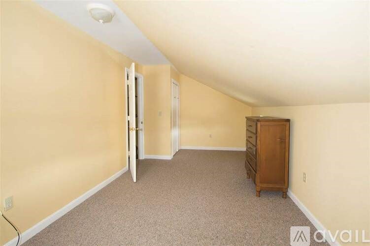 A room with a carpeted floor and a wooden cabinet.