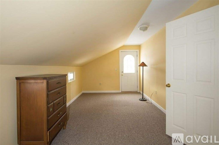 A room with a wooden dresser and a carpeted floor.
