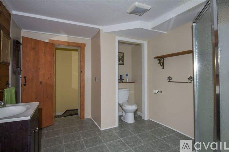 A bathroom with a toilet, sink, and shower.