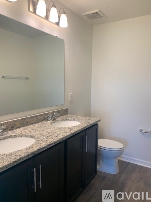 A bathroom with a toilet, sink, and mirror.