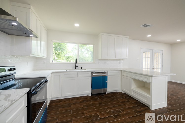 A kitchen with white cabinets and a black countertop.