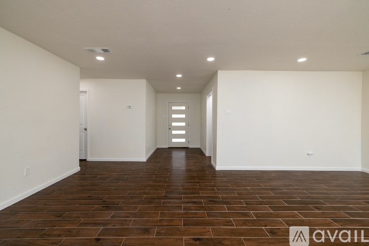 A room with wooden flooring and white walls.