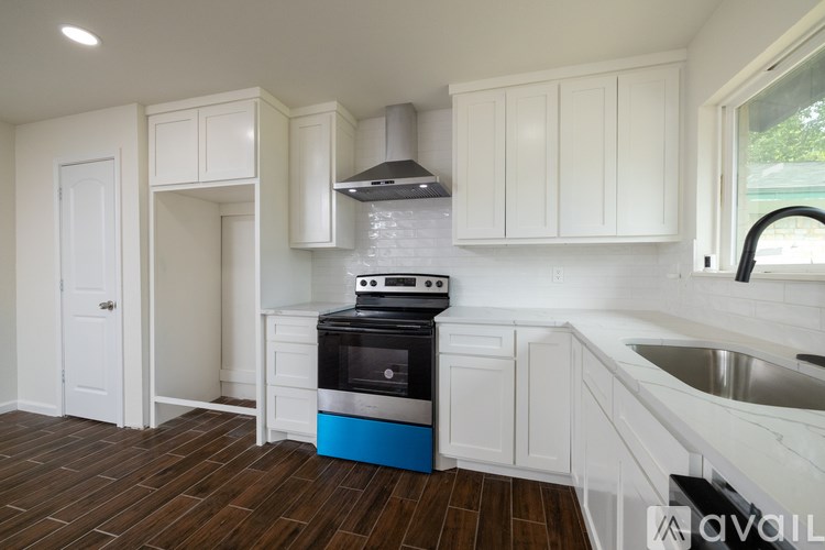 A kitchen with white cabinets and a blue island.