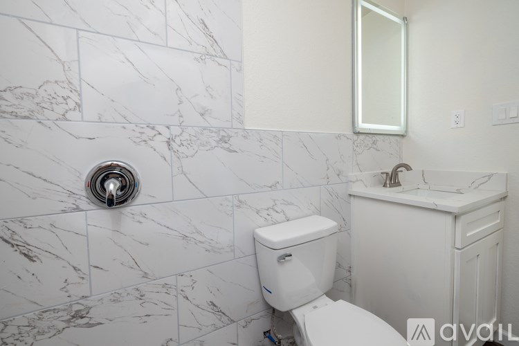 A white toilet in a bathroom with marble tiles.