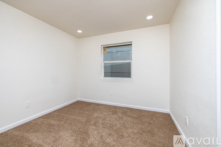 A room with a carpeted floor and a window.