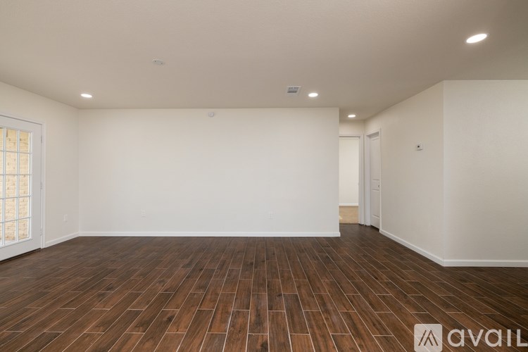 A room with wooden flooring and white walls.
