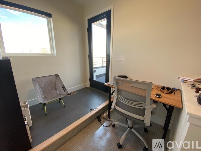 A room with a desk, chair, and a window.