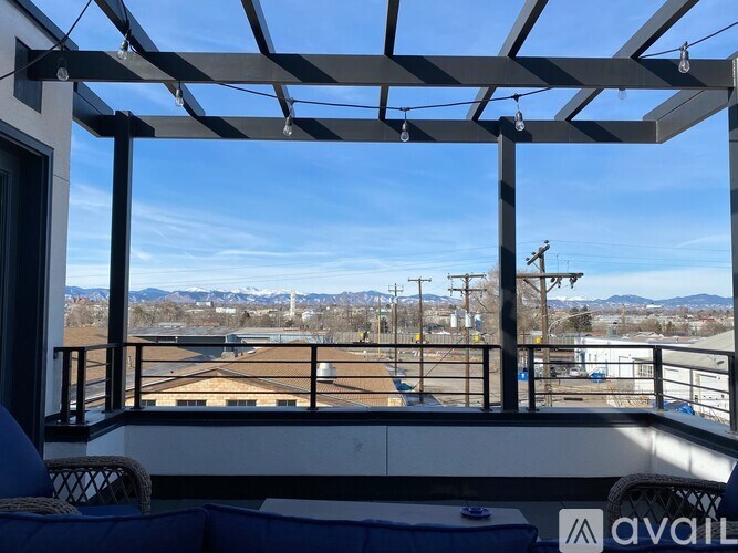A balcony with a metal pergola and a view of the mountains.