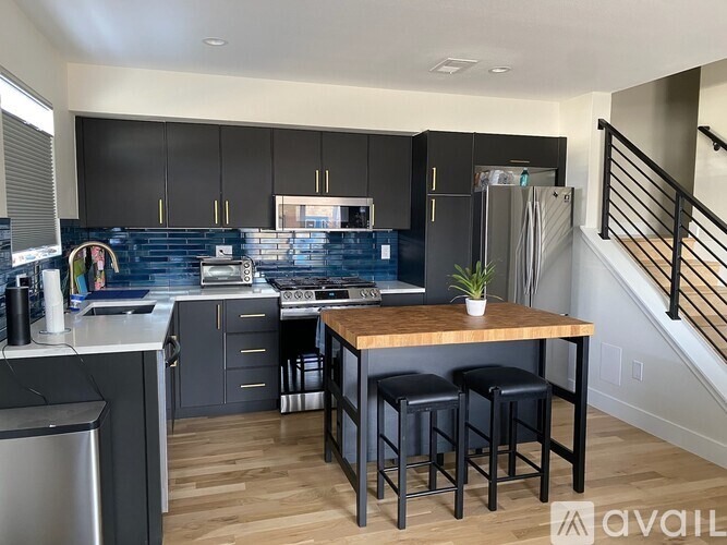 A kitchen with a blue backsplash and wooden floors.