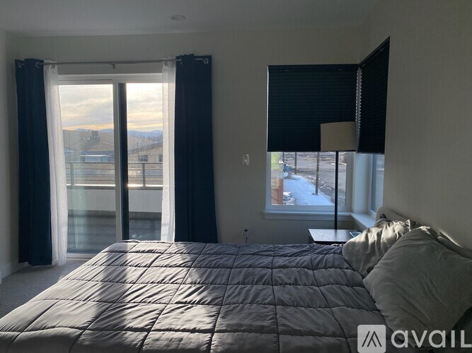 A bedroom with a large bed and a view of the outdoors through the window.