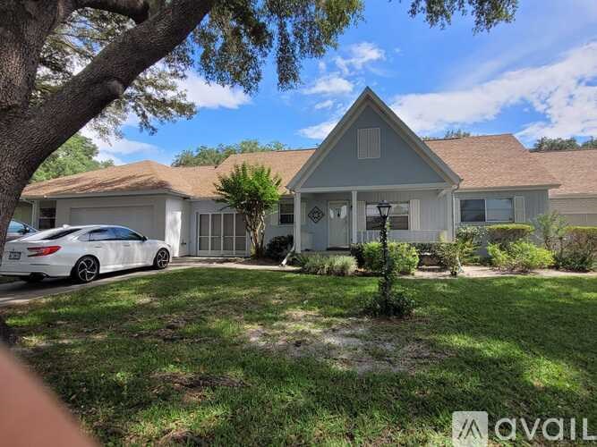 A white car is parked in front of a house.