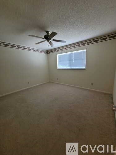 A room with a ceiling fan and a window.