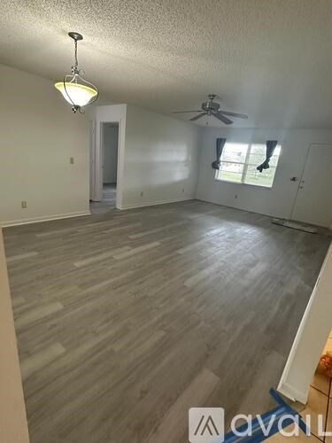 A room with wooden flooring and a ceiling fan.