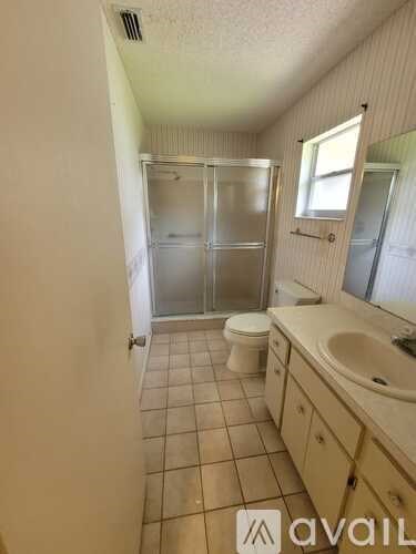 A bathroom with a toilet, sink, and shower.