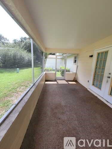 A room with a carpeted floor and a door leading to a backyard.