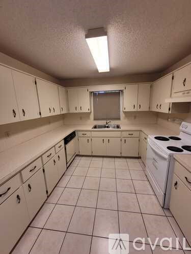 A kitchen with white cabinets and a white fridge.