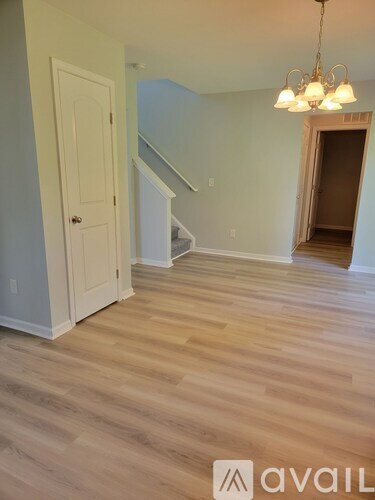 A room with wooden flooring and a chandelier.