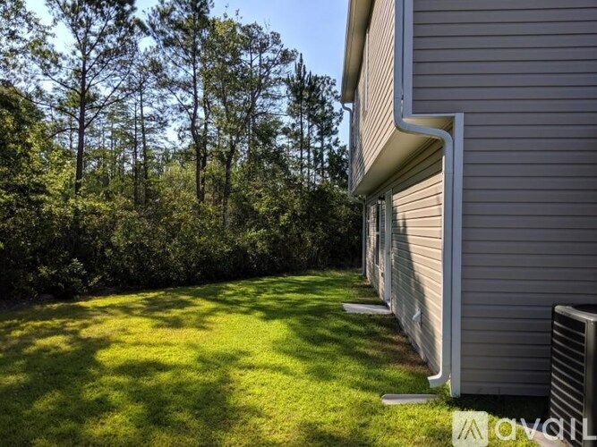 A house with a well-kept lawn and trees in the background.